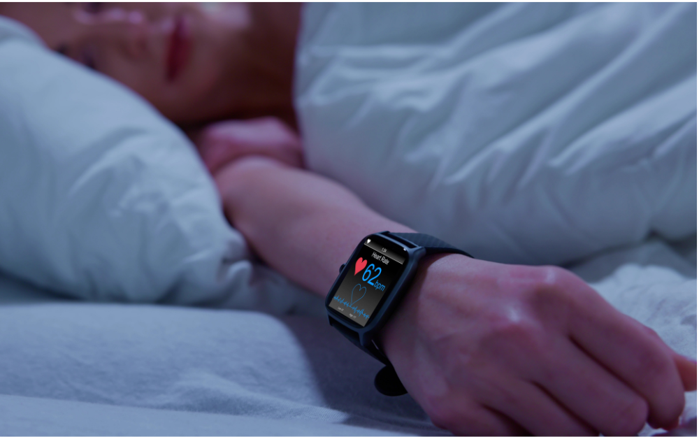 Person sleeping with a smartwatch tracking heart rate, illustrating how sleep score data is measured